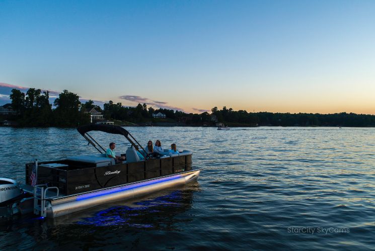 A pontoon glides across Smith Mountain Lake at Sunset