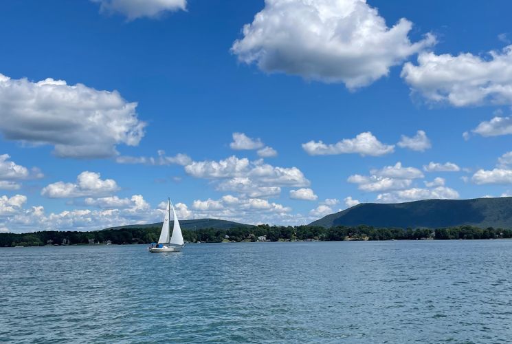 Sailboat gliding in front of Smith Mountain