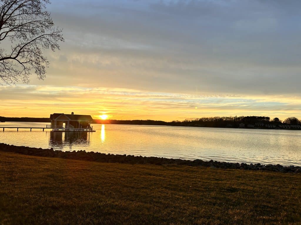 The sun dips below Smith Mountain Lake, painting the sky gold.