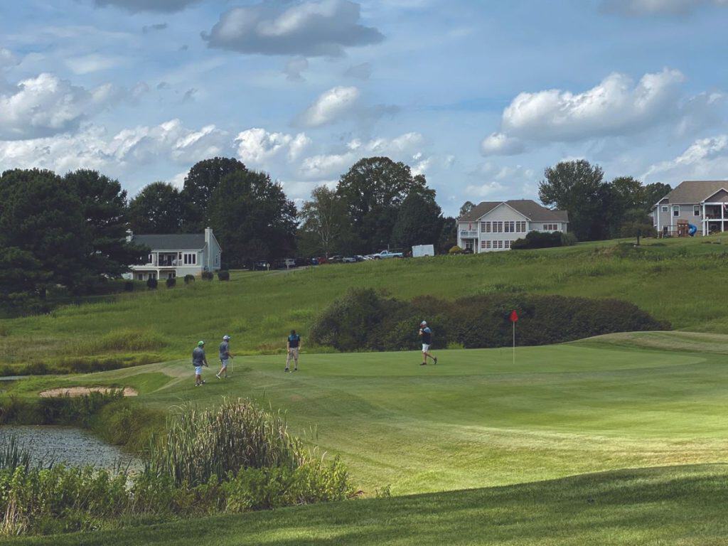 Golfer putt out on a green at Copper Cove Golf Club at Smith Mountain Lake, VA.
